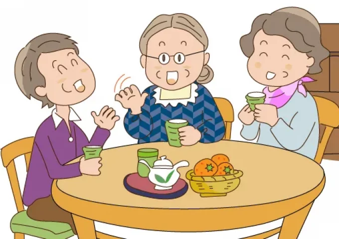 Three women sitting at a table chatting and drinking tea